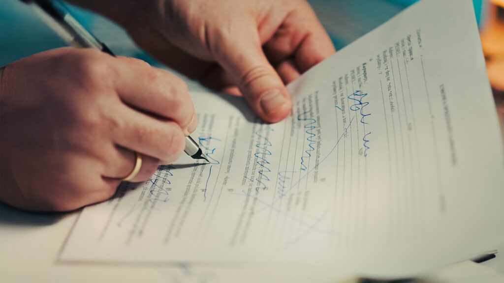 Handen ondertekenen een juridisch document - BSA-brief over softwarelicenties